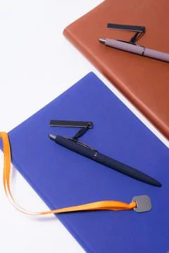 Notebook and pen on white background Photos