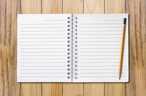 Notebook and pencil It is located on a brown wooden floor. Stock Photos