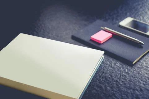 Notebook and phone on a table Stock Photos