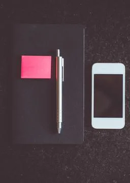 Notebook and phone on a table Stock Photos