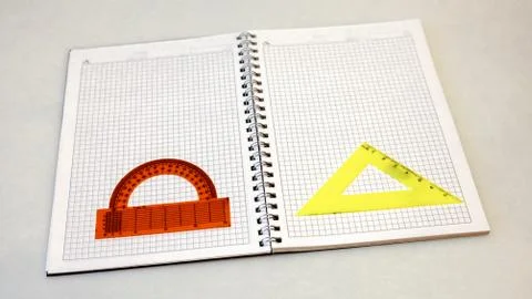 A notebook and a protractor on a light background Stock Photos