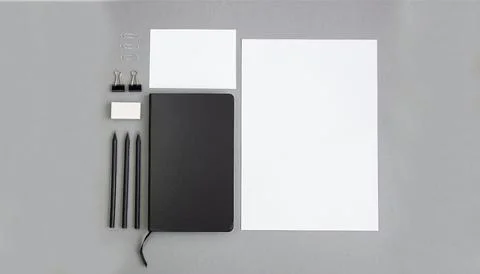 Notebook and stationery on a gray background, mockup. Flat lay. Stock Photos