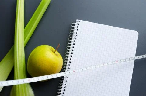 Notebook with apple, celery and measuring tape Foto stock