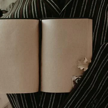 Notebook in autumn composition on the striped jacket. Stock Photos