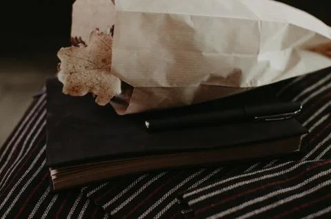 Notebook in autumn composition on the striped jacket. Stock Photos