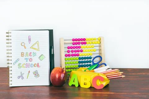 Notebook with back-to-school drawing. School material with abacus, pencils. Stock Photos