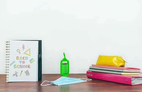 Notebook with back to school drawing. Study utensils, mask and gel. Stock Photos