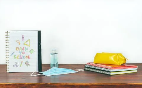 Notebook with back to school drawing. Study utensils, mask and gel. Stock Photos