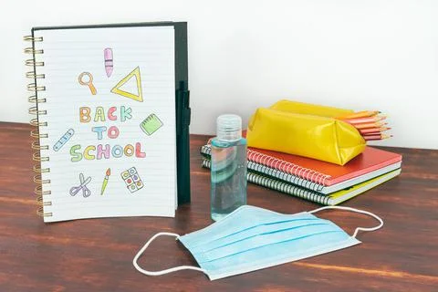 Notebook with back to school drawing. Study utensils, mask and gel. Stock Photos