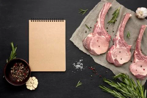 Notebook beside raw meat on baking paper Photo Stock-Fotos