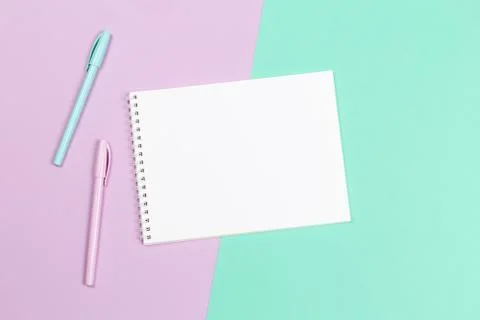 Notebook with blank page and two pens on a violet and turquoise background. F Stock Photos