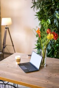 Notebook with blank screen on table in living room. Stock Photos