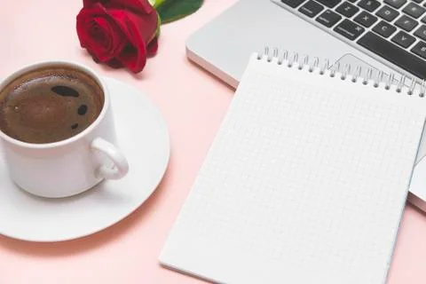 Notebook with blank sheet, black coffee Cup, red rose, laptop keyboard Stock Photos