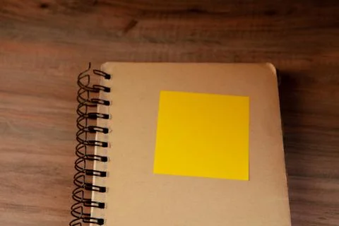 Notebook with blank yellow sticky note on wooden background. Top view Stock Photos