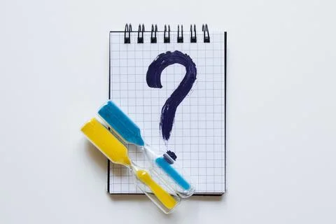 A notebook in a cage with a dark blue question mark drawn on it, next to it a Stock Photos