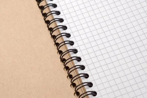 Notebook with checkered sheets on a wooden table. Close-up Stock Photos