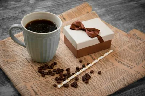 Notebook, coffee beans, cup of cofee and newspaper on gray wood Stock Photos