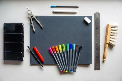 Notebook with colorful art supplies over a clear background Stock Photos