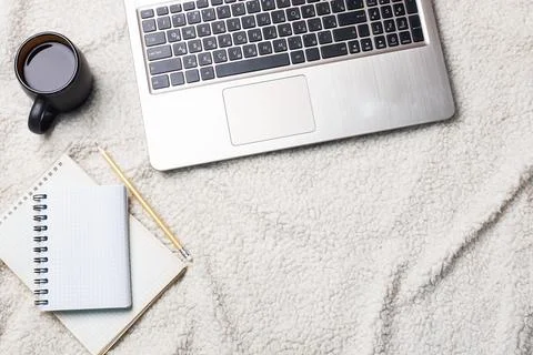 Notebook Computer and coffee lying on a white wool blanket. Concept of work.. 스톡 사진