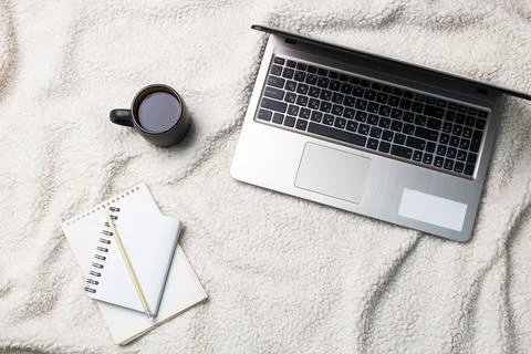 Notebook Computer and coffee lying on a white wool blanket. Concept of work.. Foto stock