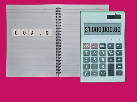 A notebook containing written objectives. Wooden word: Setting Financial Go.. Stock Photos