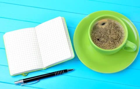 Notebook with cup of coffee on table Stock Photos