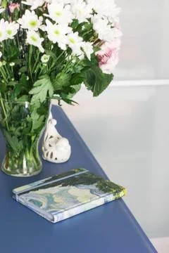 Notebook diary book on a blue table with bouquet of pink hydrangeas in the ro Stock Photos