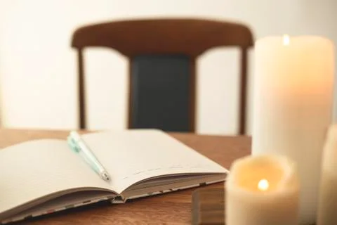 Notebook for diary entries on the table with candles. Stock Photos