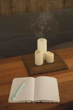 Notebook for diary entries on the table with candles. Stock Photos
