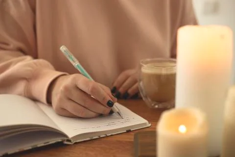 Notebook for diary entries on the table with candles. Stock Photos