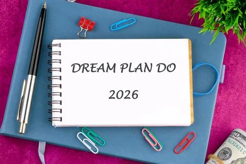 A notebook displaying the words DREAM PLAN DO and 2026 rests on a blue journal Stock Photos
