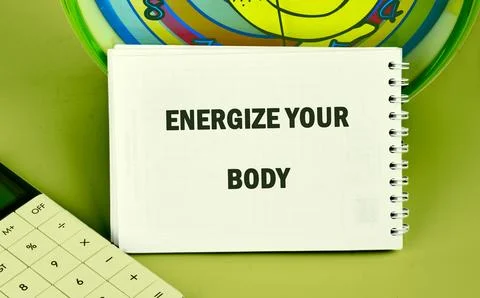 A notebook displays the text ENERGIZE YOUR BODY. Beside it, a calculator sits on Stockfoto's
