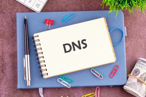 Notebook With DNS Abbreviation on a Desk Surrounded by Stationery Items and.. Stock Photos