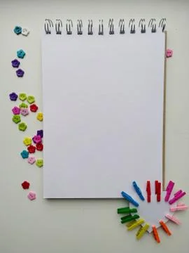 Notebook for drawing on a white ground with multi-colored buttons, clothespins Stock Photos