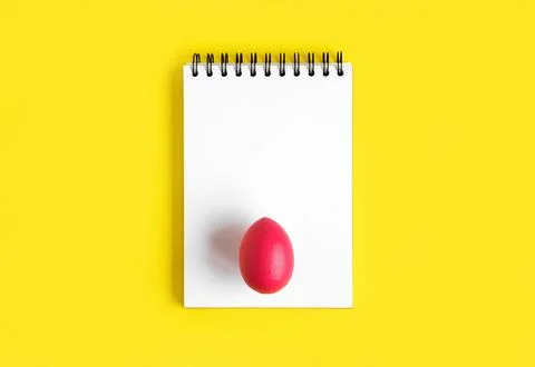 Notebook with Easter Eggs. Spiral notepad on spring yellow background. Top .. Stock Photos