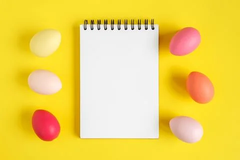Notebook with Easter Eggs. Spiral notepad on spring yellow background. Top .. Stock Photos