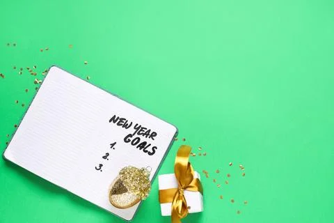Notebook with empty to do list for new year and Christmas gift on green backg Stock Photos