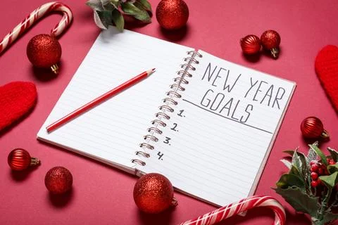 Notebook with empty to do list, pencil and Christmas decor on red background. Stock Photos