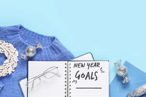 Notebook with empty to do list, sweater and Christmas decor on blue backgroun Stock Photos