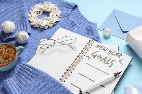 Notebook with empty to do list, sweater and Christmas decor on blue backgroun Stock Photos