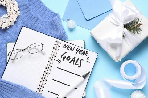 Notebook with empty to do list, sweater and Christmas gift on blue background Stock Photos