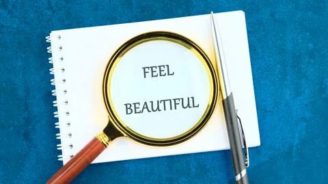 A notebook features the words feel beautiful highlighted through a magnifyi.. Stock Photos