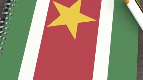 A notebook with the flag of Suriname and a lying pen Stock Footage 167828310