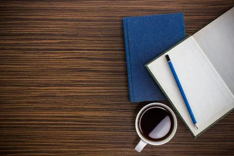 Notebook with glasses and coffee on table Stock Photos