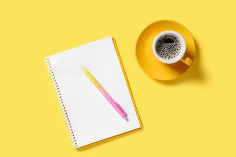Notebook with gradient pen and cup of coffee on yellow background Stock Photos