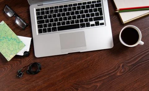 Notebook with hot coffee and map on wood table Stock Photos
