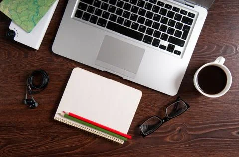 Notebook with hot coffee and map on wood table Stock Photos