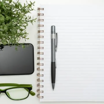 Notebook With Important Messages On Desk With Coffee, Phone And Glasses. Crutial Foto stock