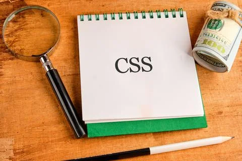 A notebook marked CSS sits on a wooden surface next to a magnifying glass and 스톡 사진