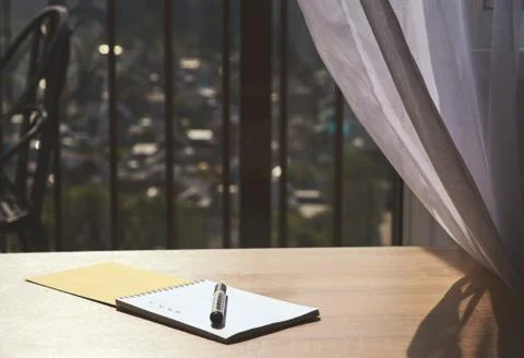 Notebook with a marker on the table by the window in the cafe Stock Photos